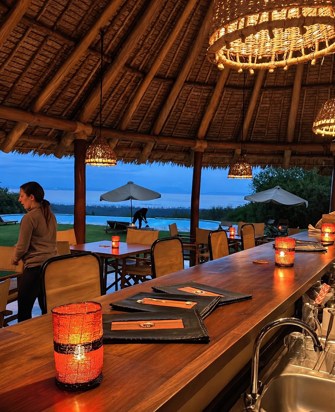 Open-air thatched bar and dining area looking out over the pool and lake
