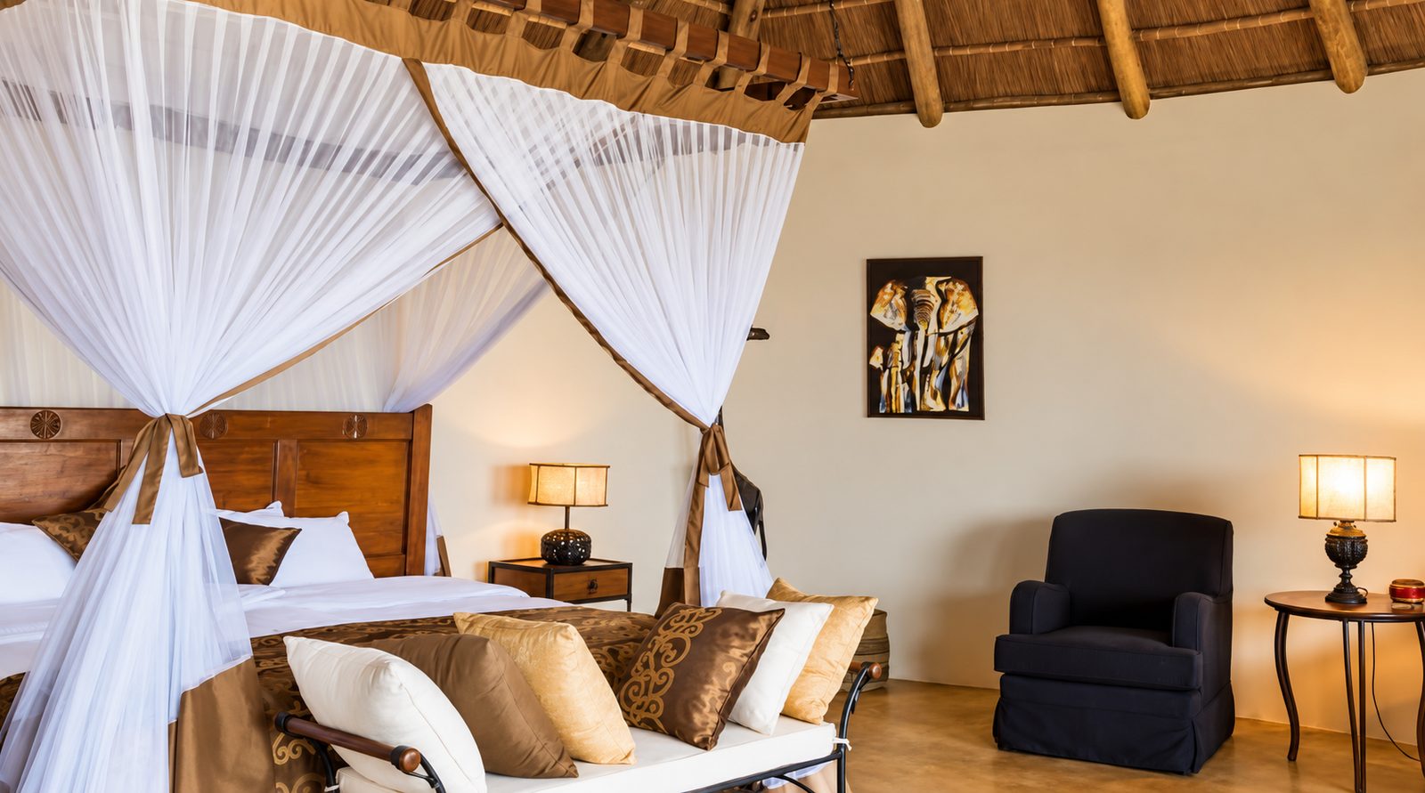 Spacious room with a canopy bed and thatched roof